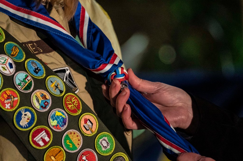 A female scout receiving her blue Eagle Scout neckerchief at a ceremony in Tacoma, Washington