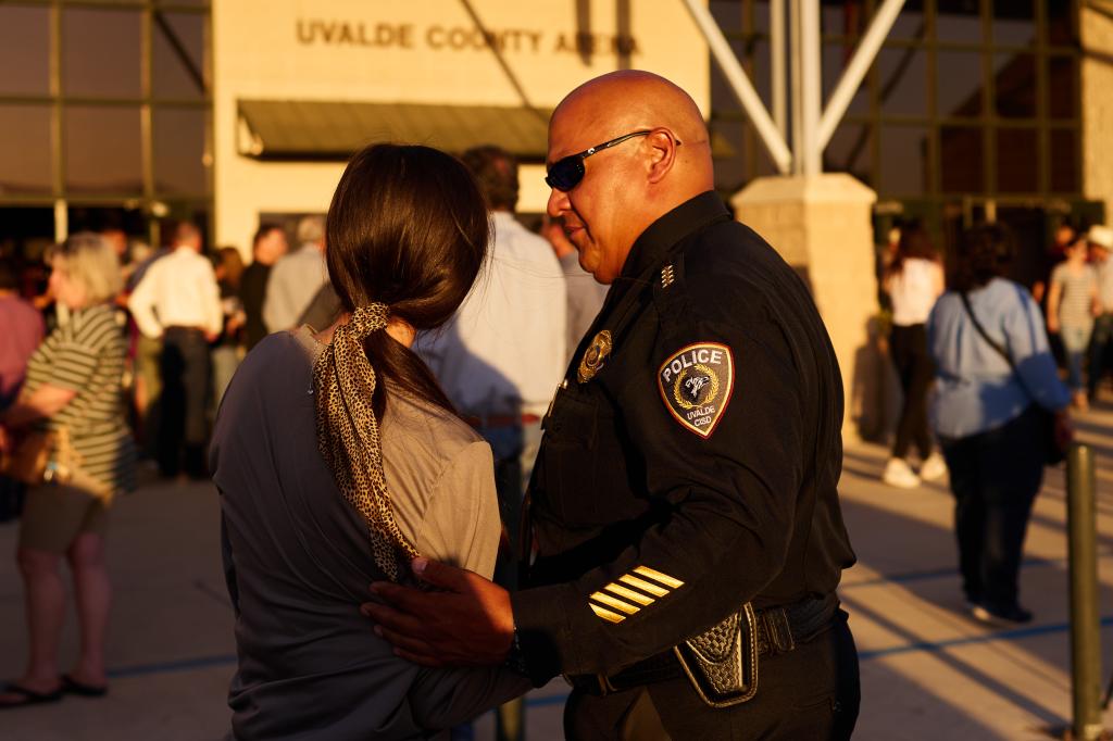 Former Uvalde School Police Chief Pete Arredondo, right, comforts a woman at a vigil at Uvalde County Arena after a mass shooting at Robb Elementary School.