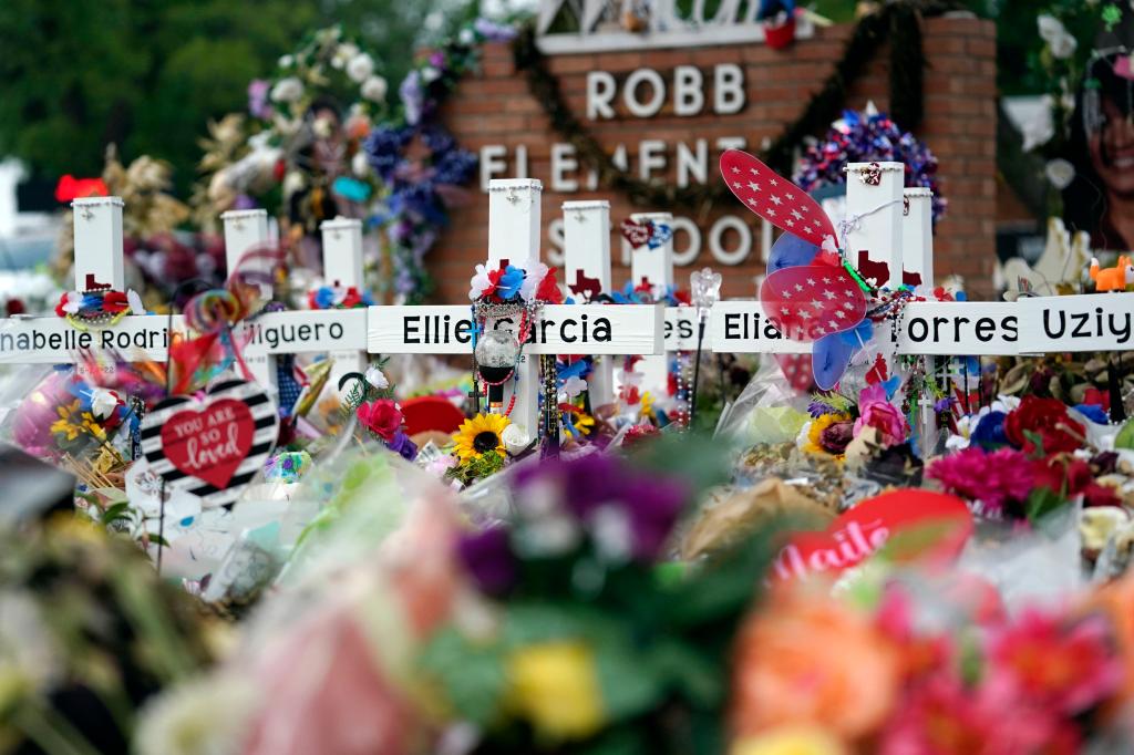 Crosses are surrounded by flowers and other items at a memorial, Thursday, June 9, 2022, for the victims of a shooting at Robb Elementary School in Uvalde, Texas.