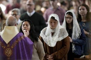 People receiving communion during a Catholic Mass at Benedictine College in Kansas on Dec. 3, 2023.