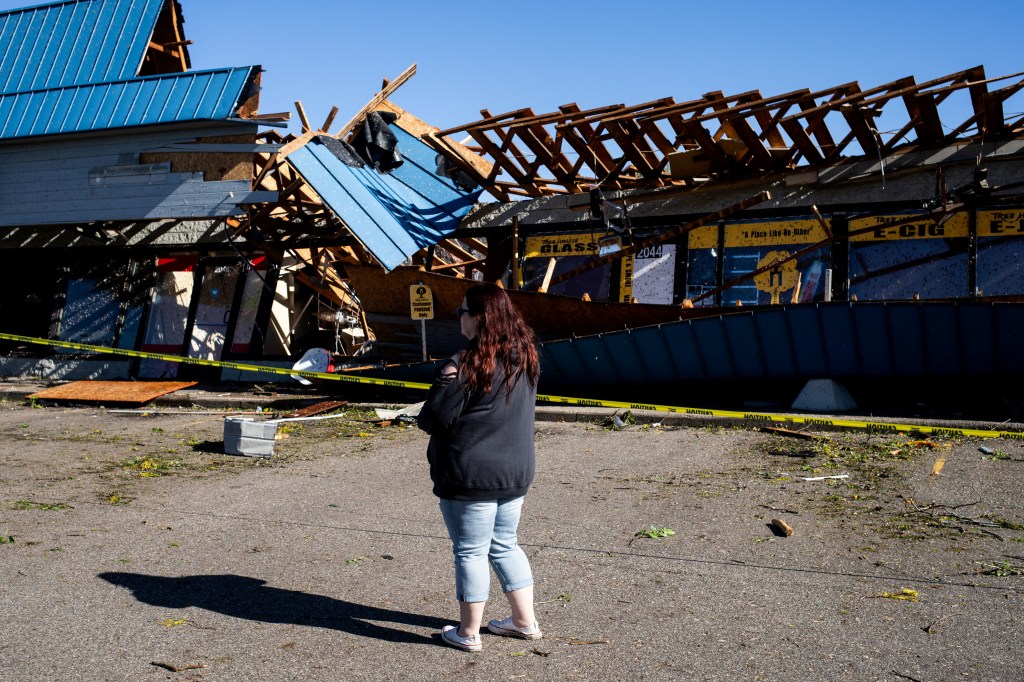 Jennifer Cory surveys businesses and buildings severely damaged after a tornado hit the area of Portage, Michigan, U.S., May 8, 2024. 