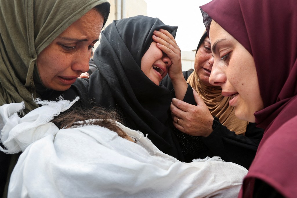 The mother and relatives of a Palestinian girl of Harara family, who was killed in an Israeli strike, react as they carry her body, at Al-Aqsa hospital in Deir Al-Balah in the central Gaza Strip, May 19, 2024. 