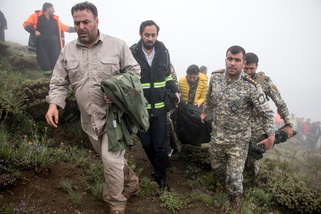 Rescue team carry a body following a crash of a helicopter carrying Iran's President Ebrahim Raisi.
