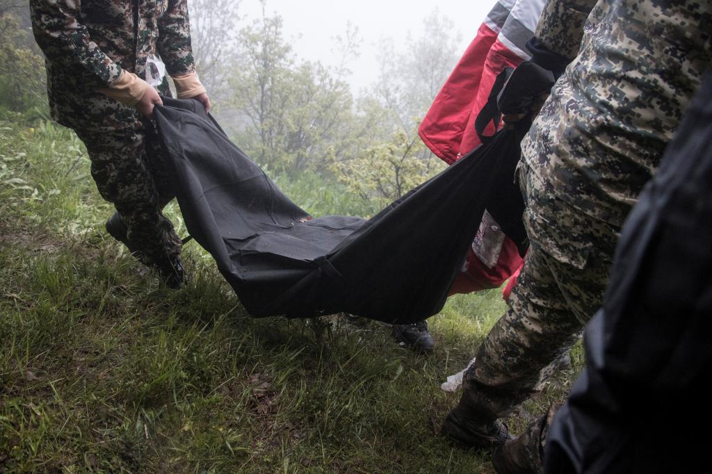 A body is removed from the crash site.