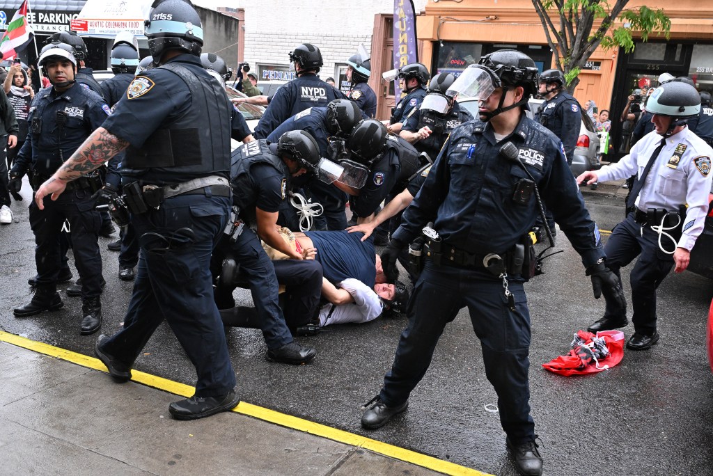 NYPD cops wrestle a pro-Palestinian protester to the ground. 