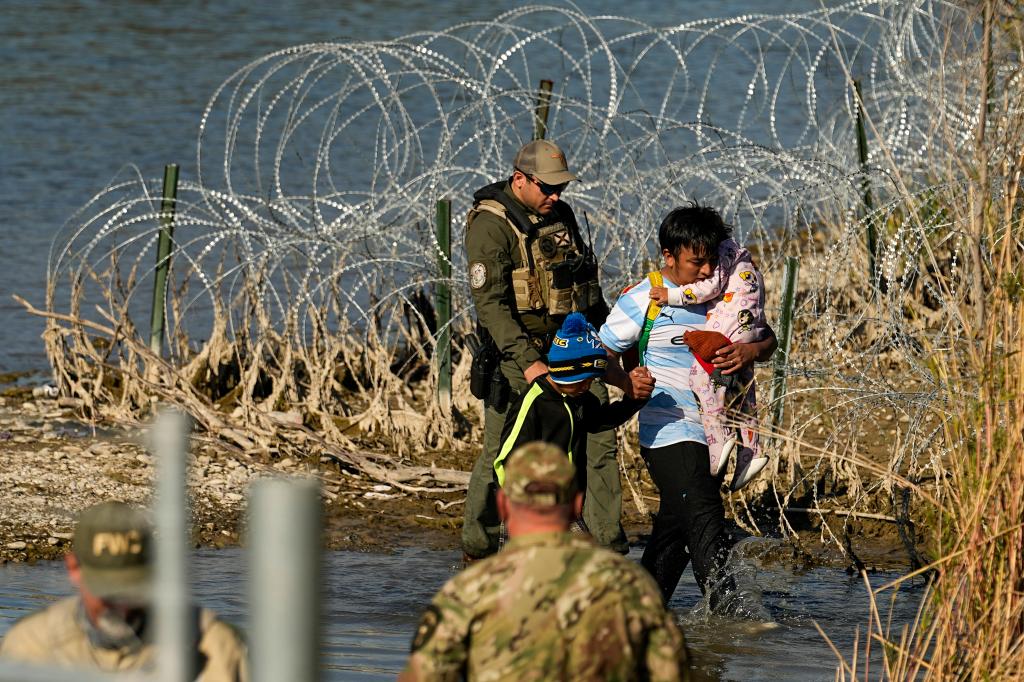 Migrants are taken into custody by officials at the Texas-Mexico border, Jan. 3, 2024, in Eagle Pass, Texas.