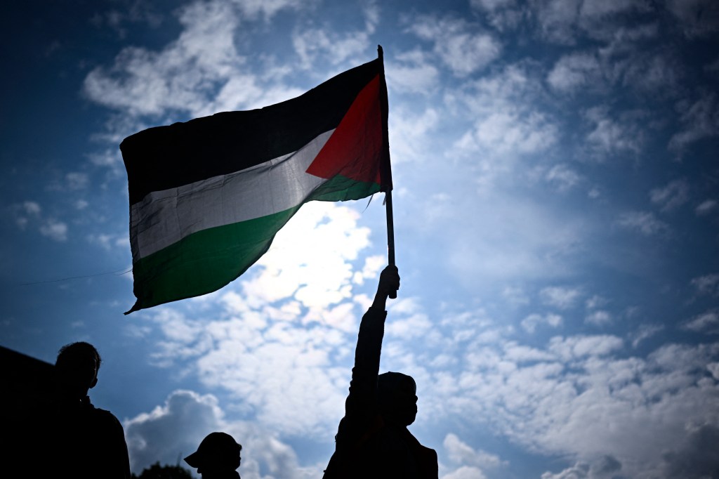 Protester holding a Palestinian flag at a rally in support of Palestinian people at Place de la Republique in Paris, May 7, 2024