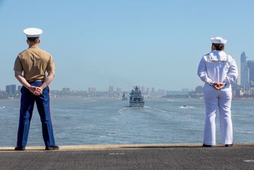 A U.S. Marine and U.S. Navy Sailor aboard the amphibious assault ship USS Bataan (LHD 5) man the rail as part of Fleet Week New York, May 22, 2024.