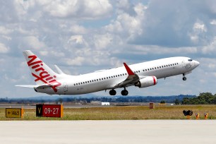 A Virgin Airlines plane taking off from Melbourne Airport, Australia
