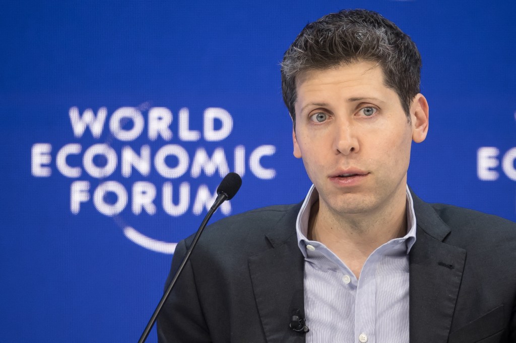 Sam Altman, CEO of OpenAI, at World Economic Forum in Davos, standing in front of a microphone