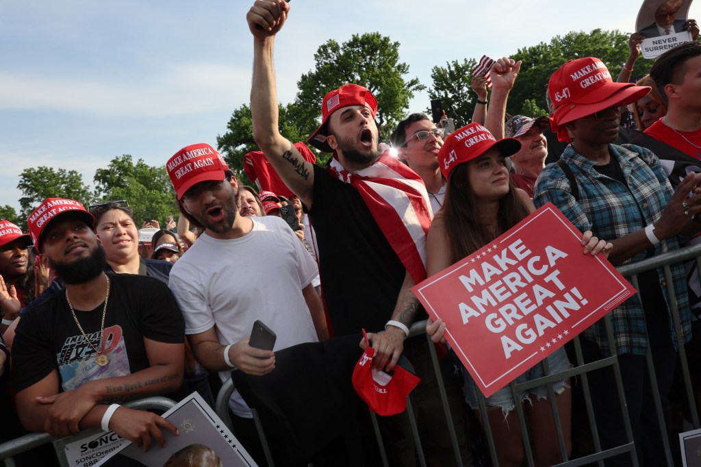Supporters of former President Donald Trump watch as he holds a rally in the historical Democratic district of the South Bronx on May 23, 2024 in New York City