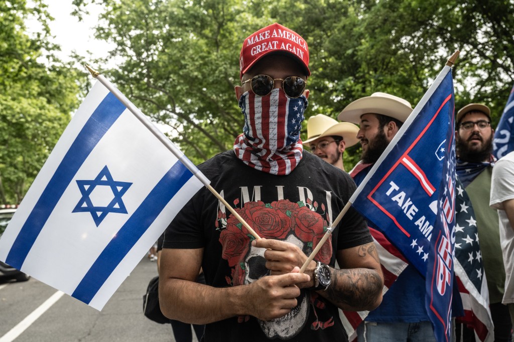  A supporter of former U.S. President Donald Trump holds an Israeli flag as they gather outside of the Crotona Park rally venue in the Bronx borough on May 23, 2024 in New York City