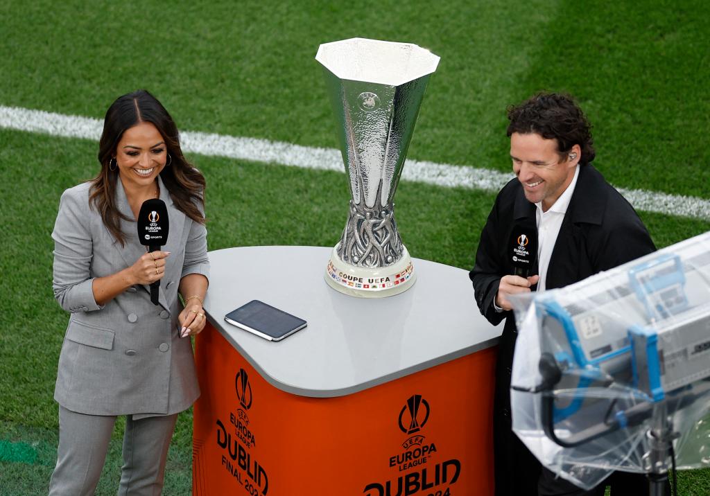Presenter Jules Breach and former player Owen Hargreaves stand next to the UEFA Europa League trophy inside the stadium before the match.