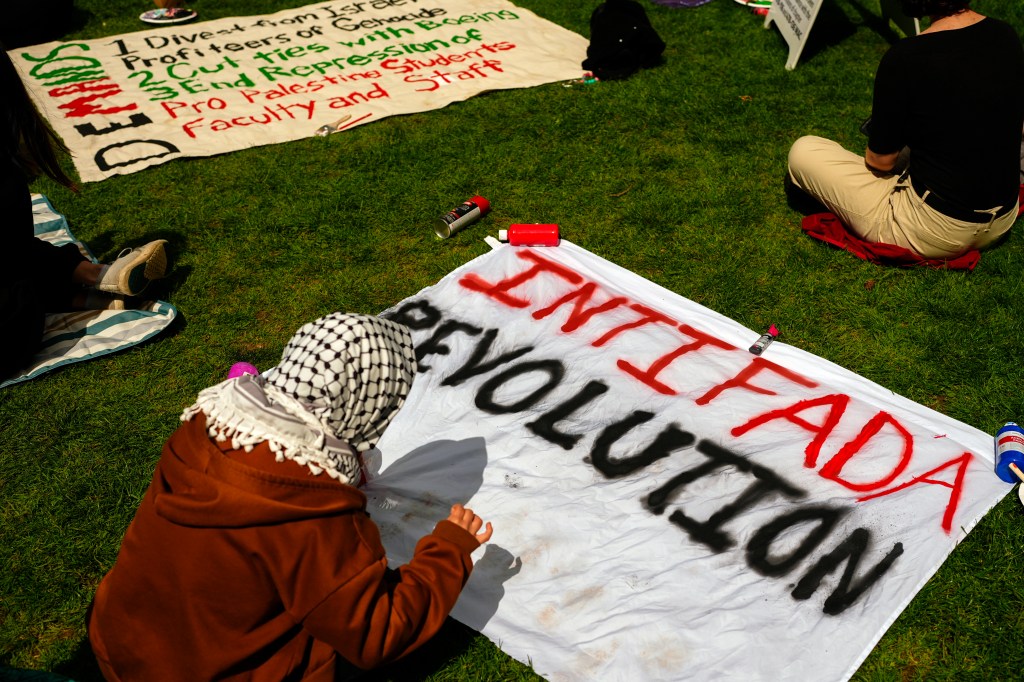 A person prepares a sign at a pro-Palestinian encampment at the University of Washington campus.