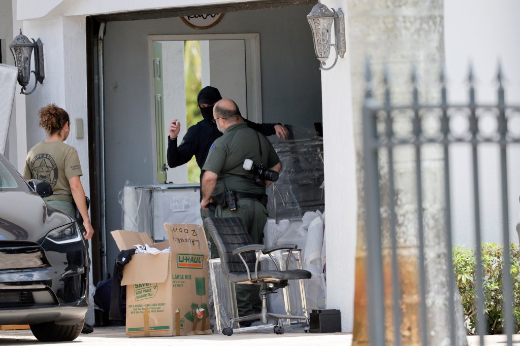 Broward Sheriff's Office personnel move items in the garage at Sean Kingston's Southwest Ranches, Fla., home, Thursday, May 23, 2024.
