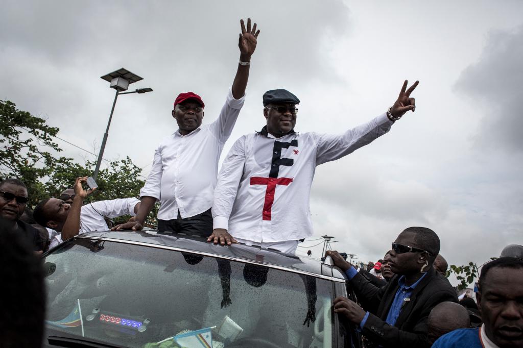 Congolese main opposition figures, leader of the Union for Democracy and Social Progress (UDPS) Felix Tshisekedi (R) and his running mate Vital Kamerhe wave from a car on Nov. 27, 2018.