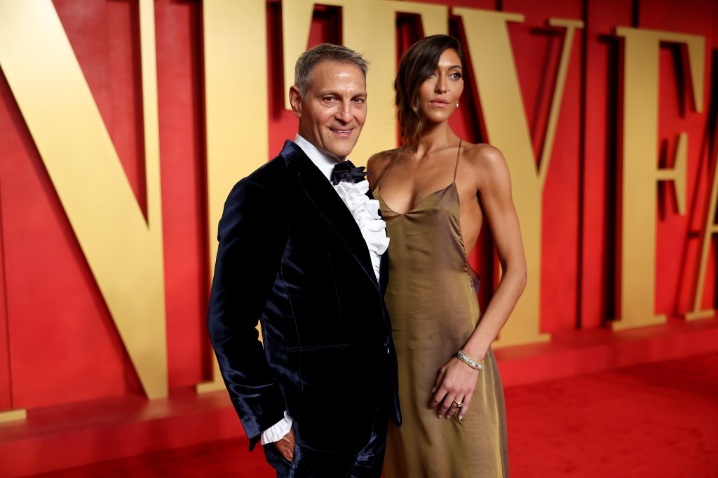 A tudexo-wearing Ari Emanuel smiles as he poses with fashion designer Sarah Staudinger during the 2024 Vanity Fair Oscar Party in March. 