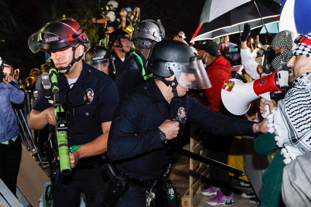 Police react while students stand their ground after police breached their encampment at the campus of the University of California, Los Angeles (UCLA) in Los Angeles, California, early on May 2, 2024