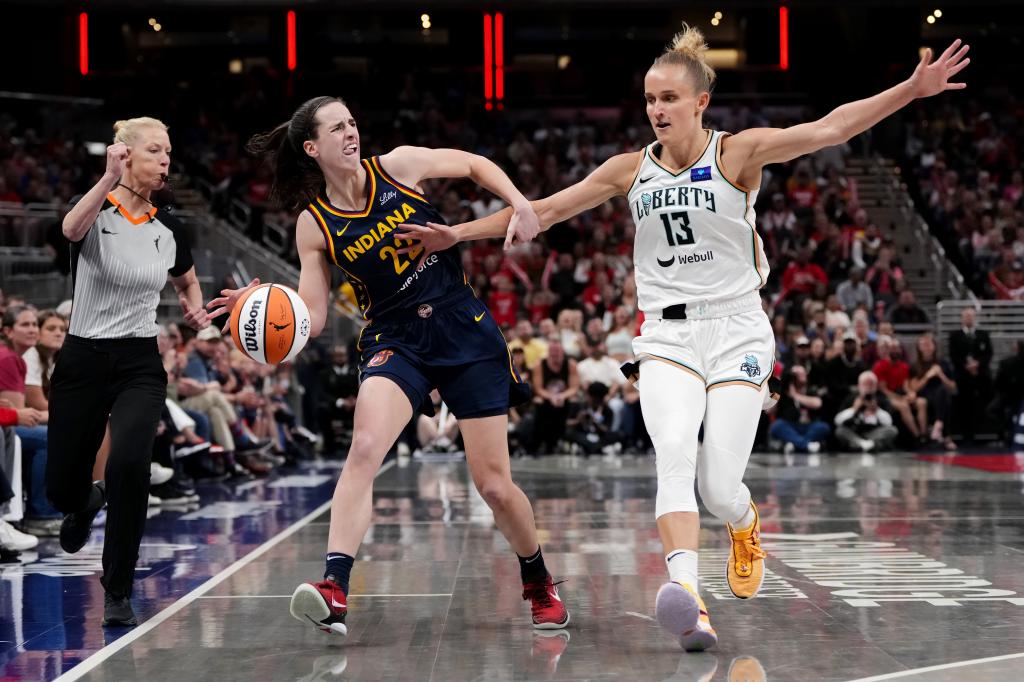 Caitlin Clark #22 of the Indiana Fever dribbles the ball while being fouled by Leonie Fiebich #13 of the New York Liberty in the third quarter at Gainbridge Fieldhouse on May 16, 2024