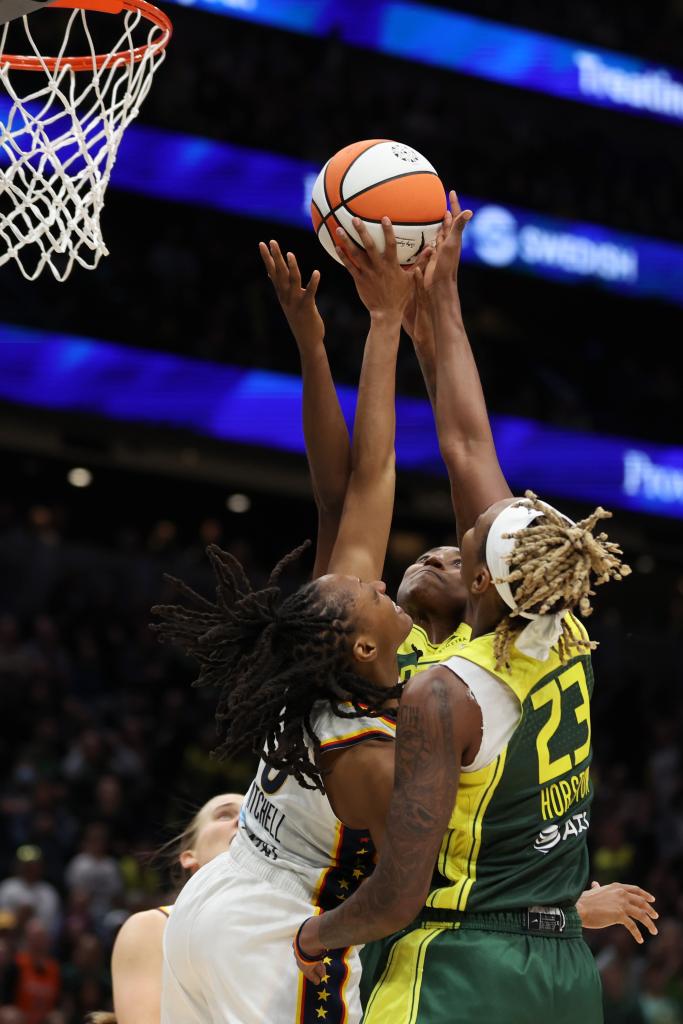 Kelsey Mitchell #0 of the Indiana Fever battles against Jewell Loyd #24 and Jordan Horston #23 of the Seattle Storm during the fourth quarter
