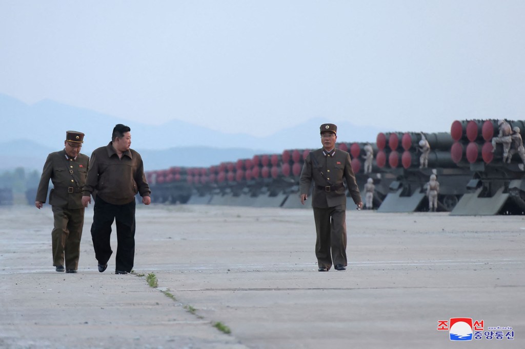 Kim Jong Un (2nd L) attending a salvo test-fire of 600mm super-large rocket artillery, at an unconfirmed location in North Korea.