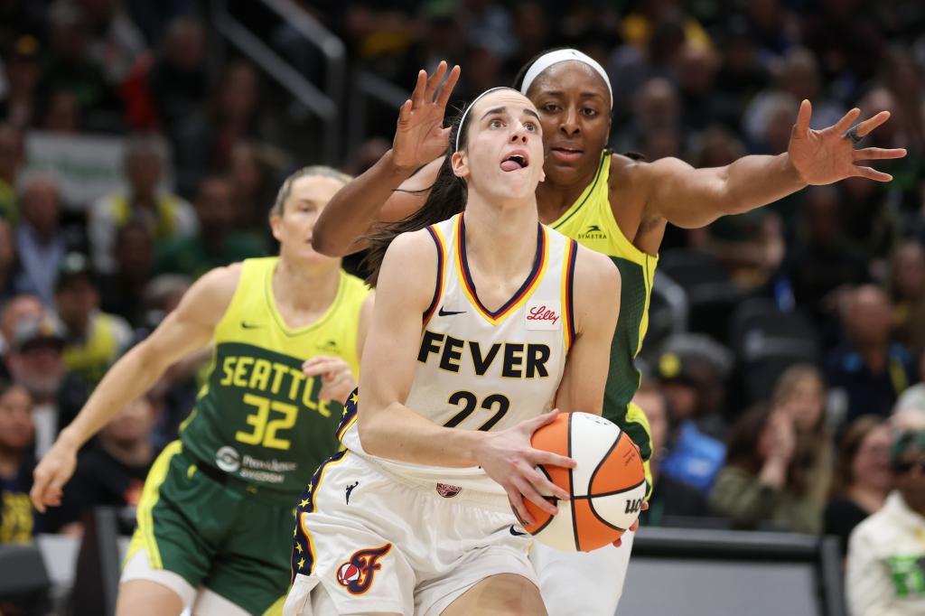 Caitlin Clark #22 of Indiana Fever driving to the basket against the Seattle Storm during a basketball game at Climate Pledge Arena