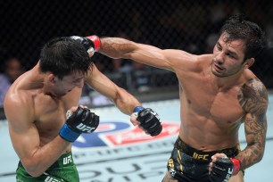 Flyweight champion Alexandre Pantoja lands a punch to the head of Steve Erceg during their title fight at UFC 301.