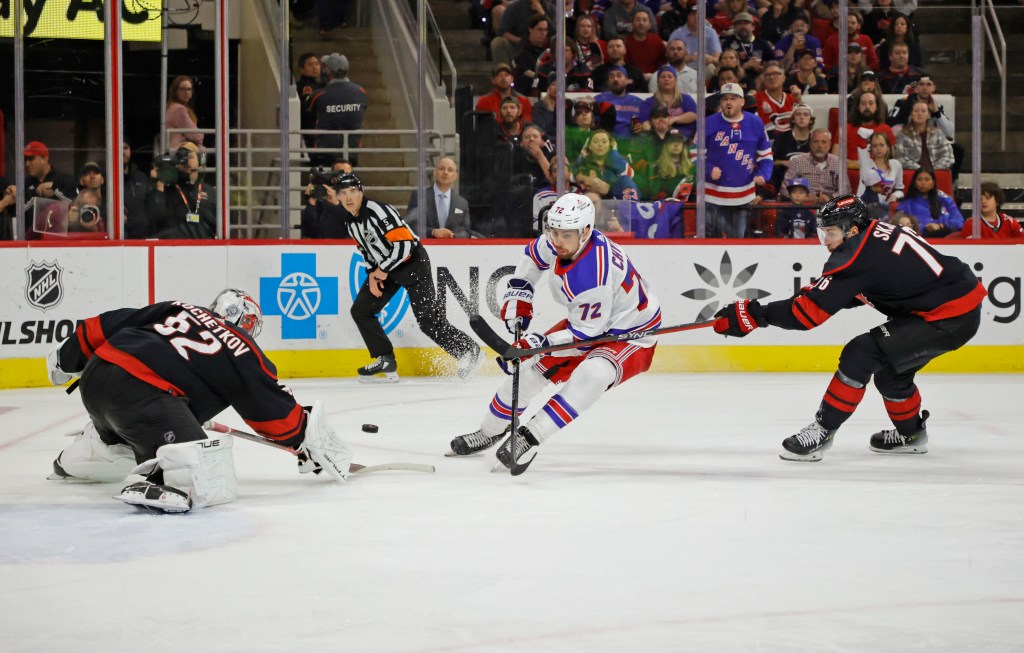 Pyotr Kochetkov #52 of the Carolina Hurricanes defends the net against Filip Chytil #72 of the New York Rangers.