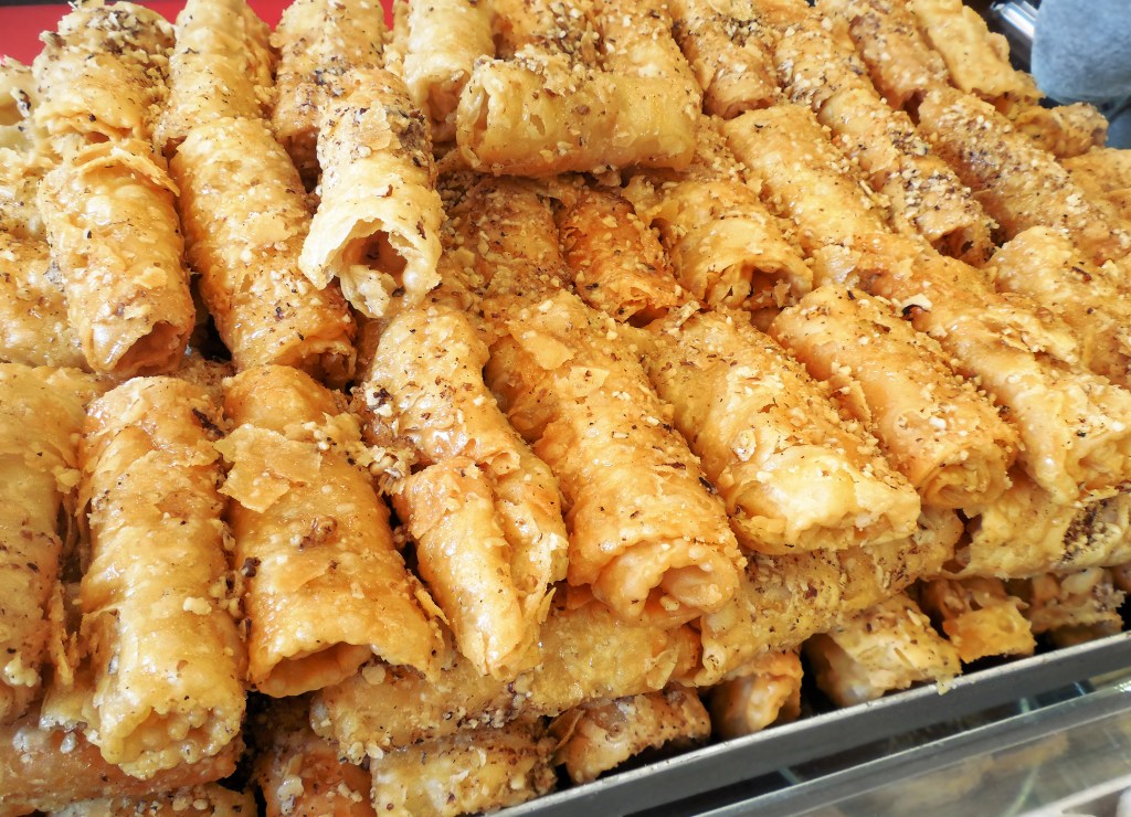 Diples, a traditional Greek Christmas dessert made of thin sheets of dough folded, fried, and drizzled with honey, cinnamon and ground walnuts