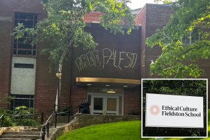 A student standing by the main campus wall at Fieldston School in the Bronx with 'FREE PALESTINE' scrawled on it