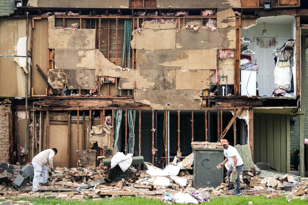 Crews work to clean up debris after a wall came down in the aftermath of a severe storm on Friday, May 17, 2024 in Houston. 