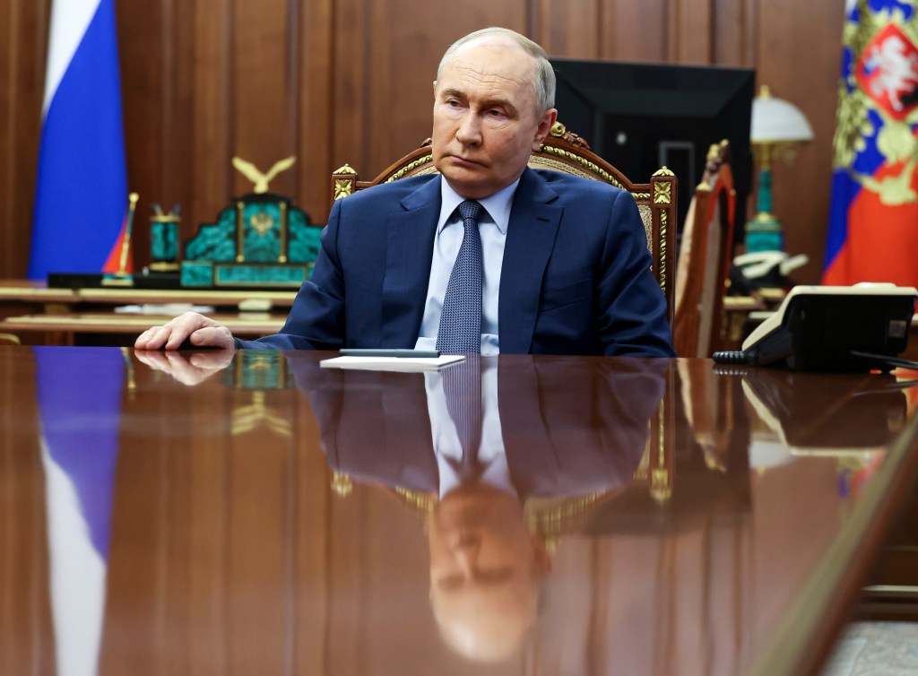 Russian President Vladimir Putin listens to Emergency Situations Minister Alexander Kurenkov and Natural Resources Minister Alexander Kozlov during their meeting at the Kremlin, in Moscow, Russia, Saturday, May 18, 2024.