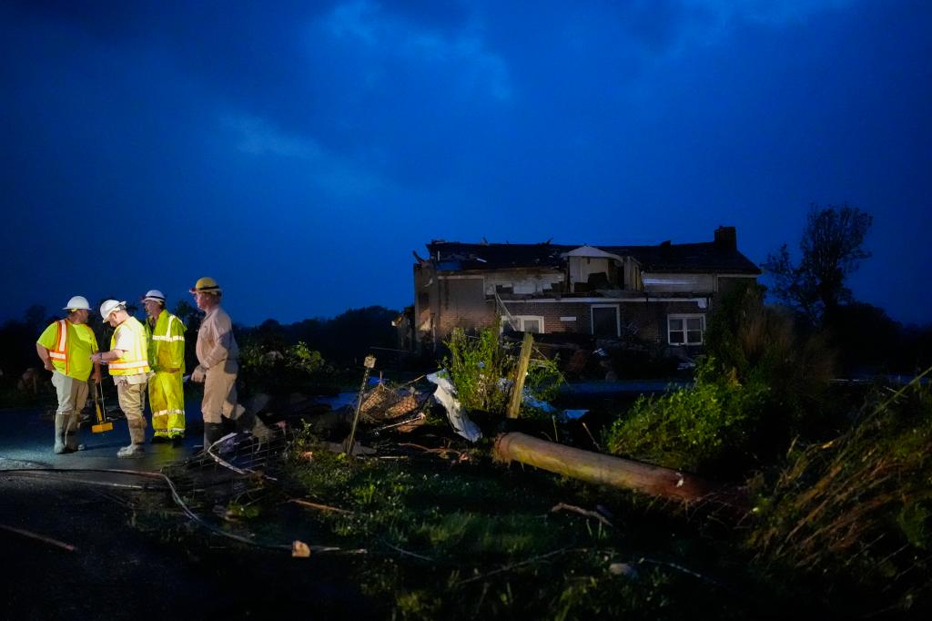 Utility workers survey storm damage along Cothran Road, Wednesday, May 8, 2024, in Columbia, Tenn