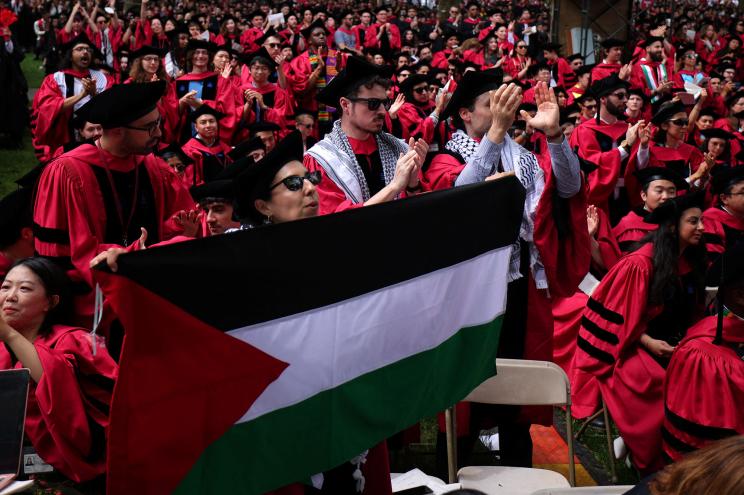 Graduating students rise in support of 13 students not able to graduate because of their participation in pro-Palestinian protests during the 373rd Commencement Exercises at Harvard University.