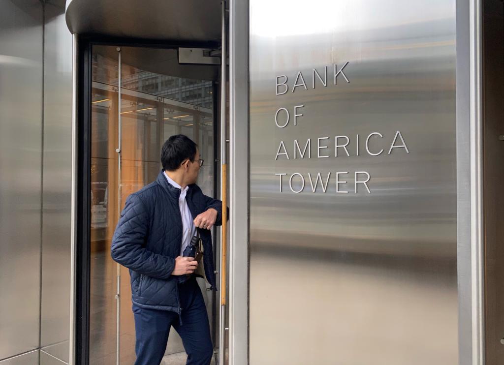 Man in coat and jeans entering Bank of America Tower on 42nd street, Manhattan, New York