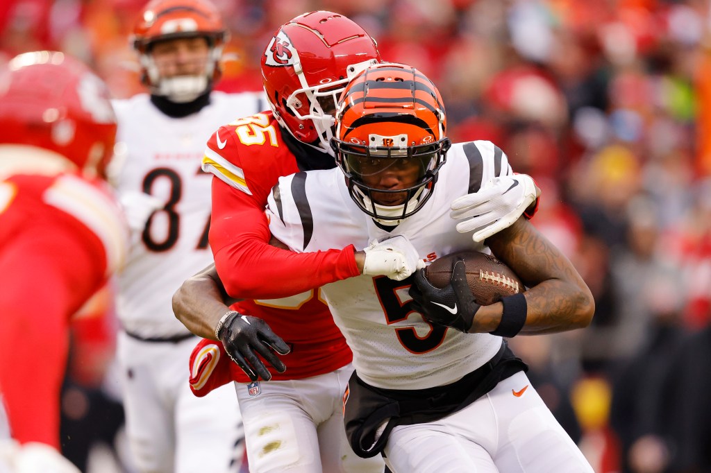 Tee Higgins is tackled by Jaylen Watson #35 of the Kansas City Chiefs during the first quarter at GEHA Field at Arrowhead Stadium.