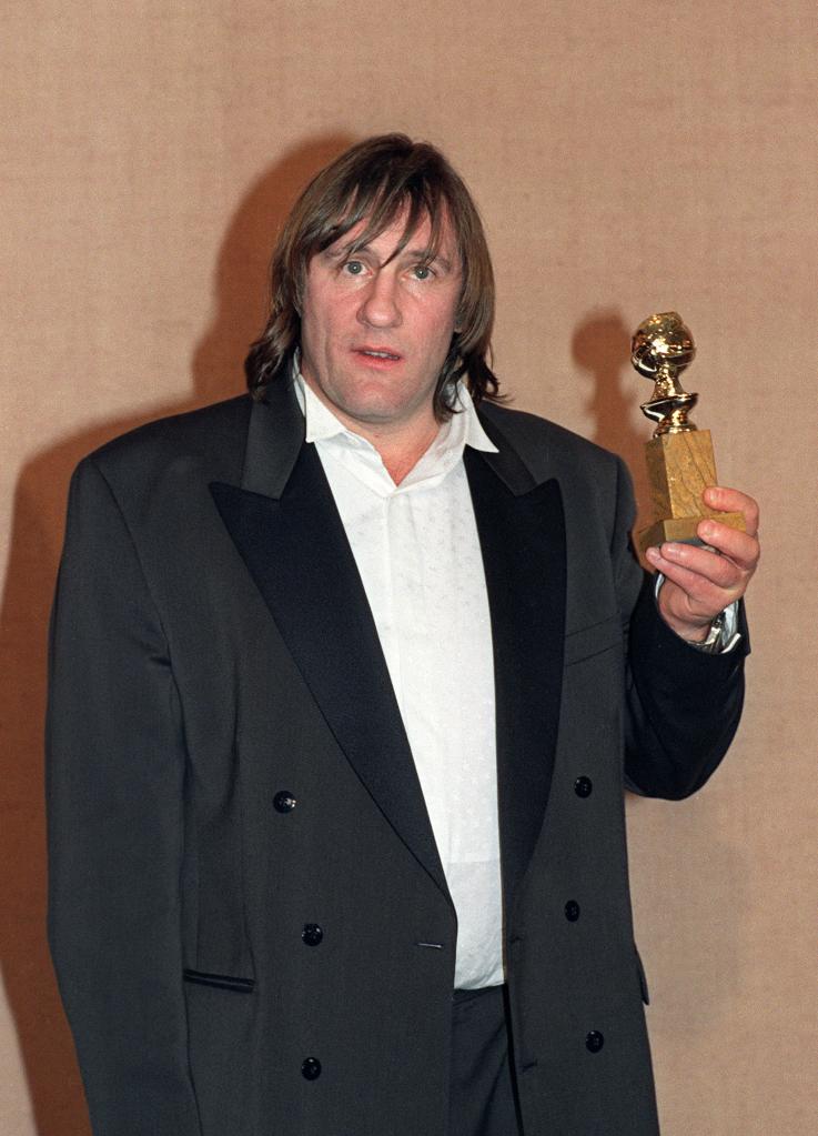 Depardieu holding his Golden Globe award he won for Best Actor in a comedy for his performance in "Green Card", during the 48th Annual Golden Globe Award ceremony.