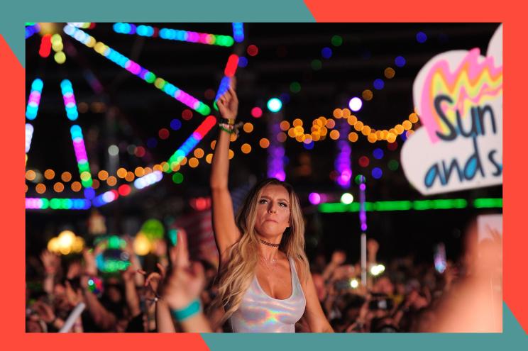 A festival goer jams out at the Electric Daisy Carnival in front of a giant ferris wheel.