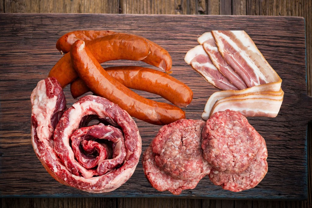 A cutting board with meat and sausages ready for grilling season