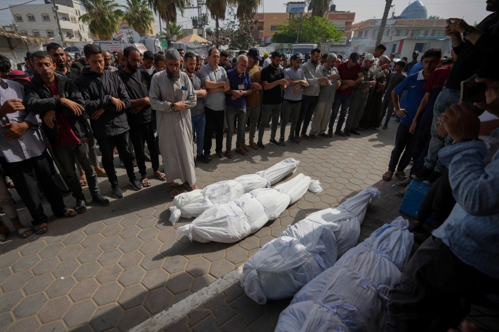 Mourners pray over the bodies of Palestinians who were killed in an Israeli airstrike in Nuseirat, at the Al Aqsa hospital in Deir al Balah, Gaza Strip, Sunday, May 19, 2024. 