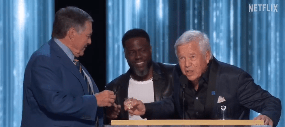 Robert Kraft (r) during the roast, alongside Kevin Hart (c) and Bill Belichick (l).