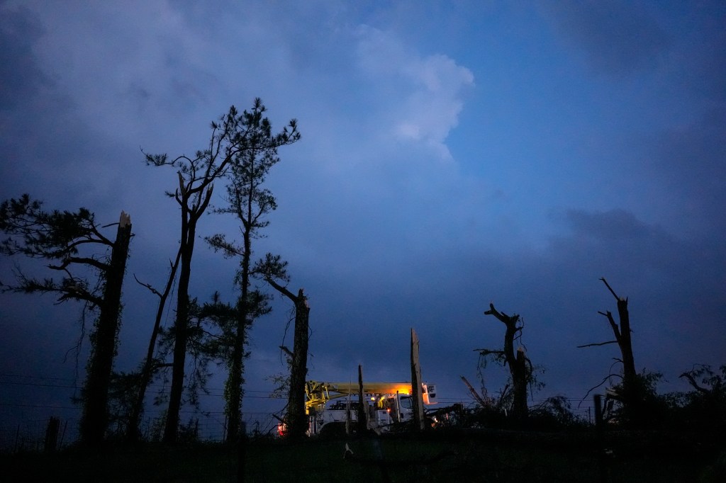 A utility truck passes damaged trees along Cothran Road, after severe storms tore through the area, Wednesday, May 8, 2024, in Columbia, Tenn.