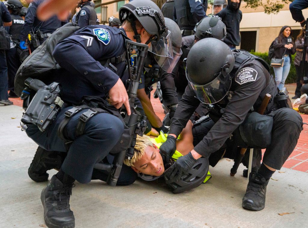 Police wrestle a pro-Palestinian protester to the ground to put wrist restraints on him at the University of California, Irvine, after police began to move protesters and an encampment off the quad, May 15, 2024, in Irvine, Calif.
