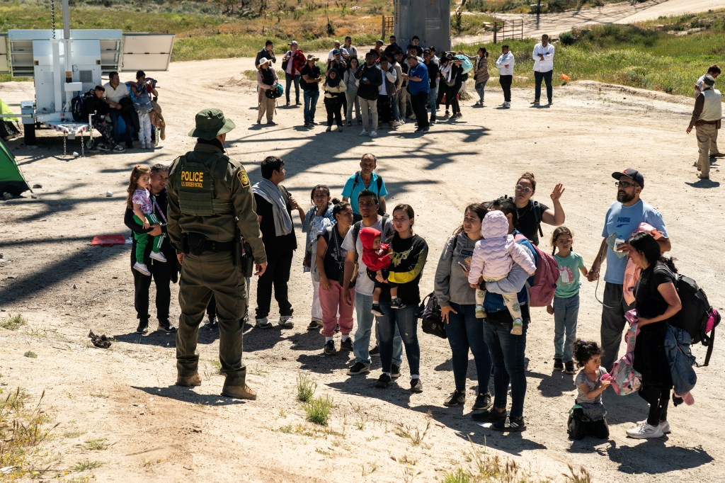 Asylum-seeking migrants line up near the border while waiting to be transported by the U.S. Border Patrol after crossing the border from Mexico into the U.S. in Jacumba Hot Springs, California, U.S. April 29, 2024.  REUTERS