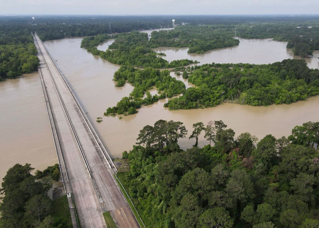 Bridge over Lake Houston closed due to high water levels, with surrounding trees and roadway visible