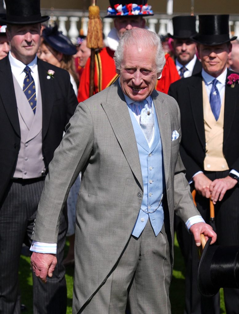 King Charles III of Britain interacting with guests at a Royal Garden Party at Buckingham Palace