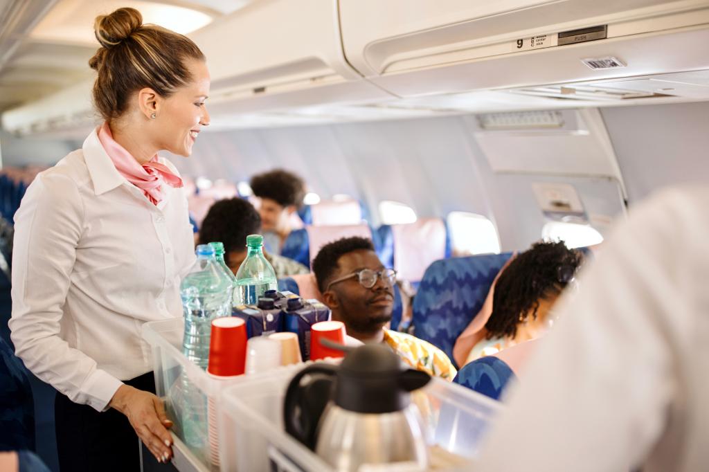 airline steward serving drinks on a plane