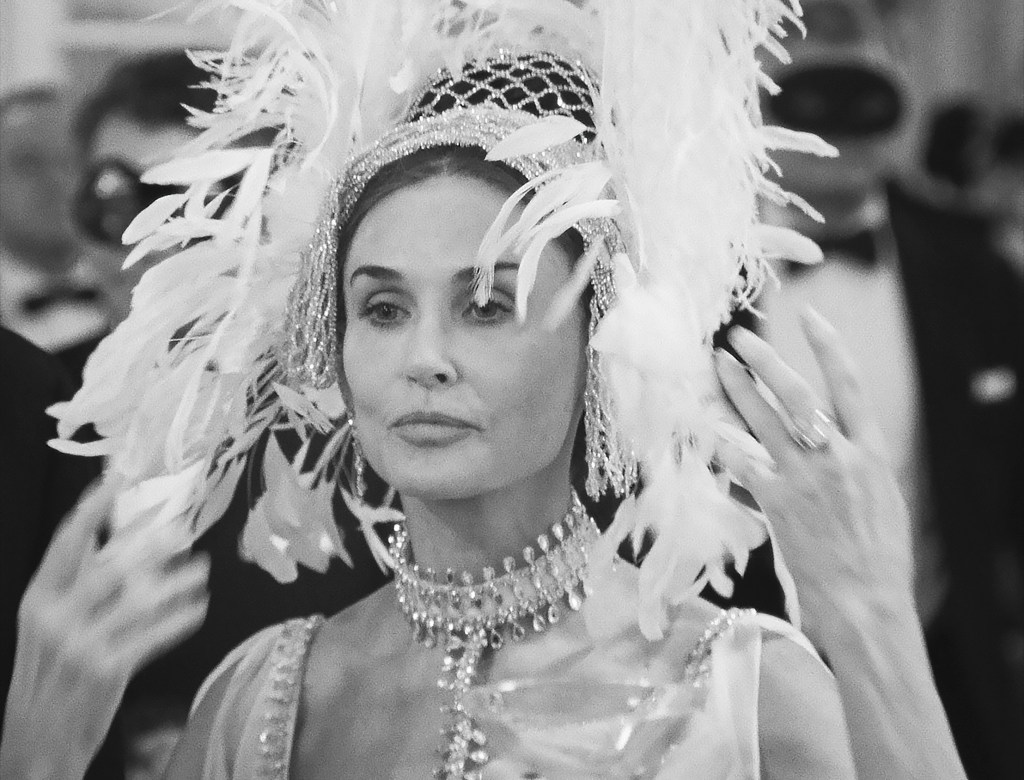 Demi Moore portraying Ann Woodward, a high society woman possibly suspected of murder, dressed in a feathered headdress for the series 'Feud: Capote vs the Swans' (Season 2, Episode 203, aired Feb 7, 2024)