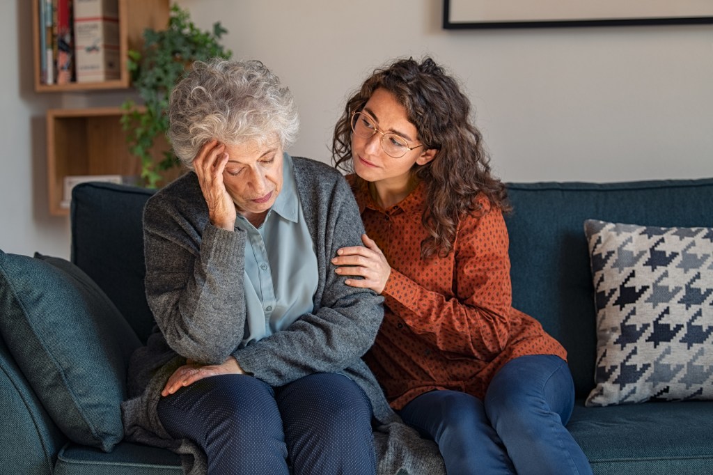 Caring daughter comforting frustrated unhappy senior woman. 