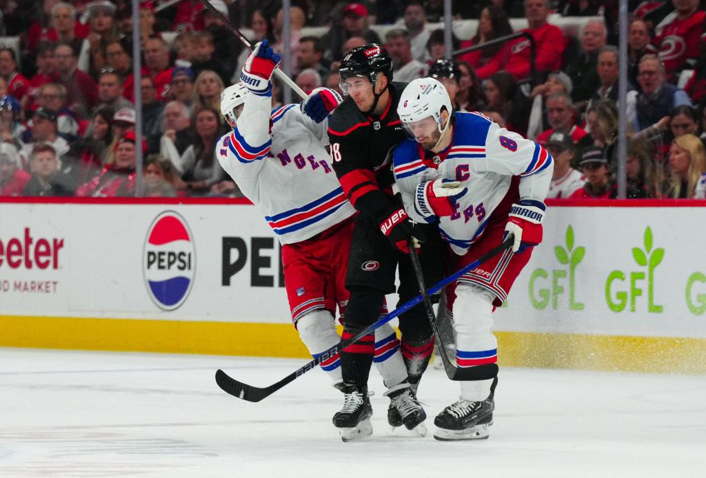 Hurricanes center Martin Necas (88) is checked by New York Rangers center Vincent Trocheck (16) and defenseman Jacob Trouba (8) during the third period in game six.